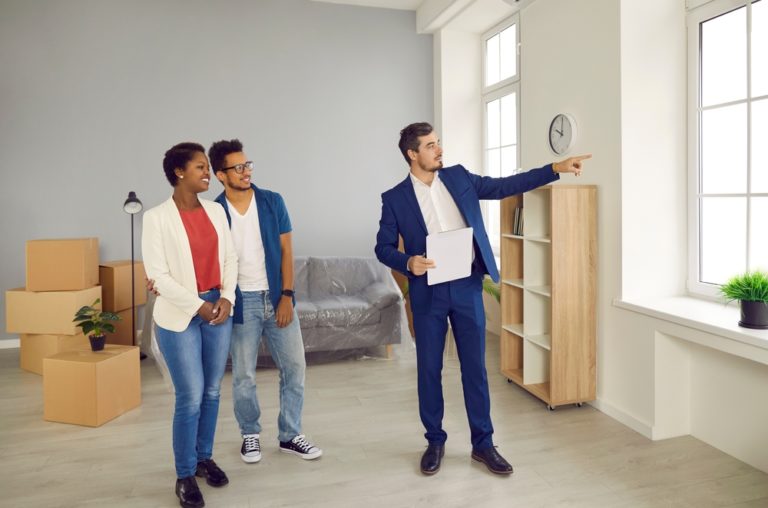 Real estate agent showing two buyers a home