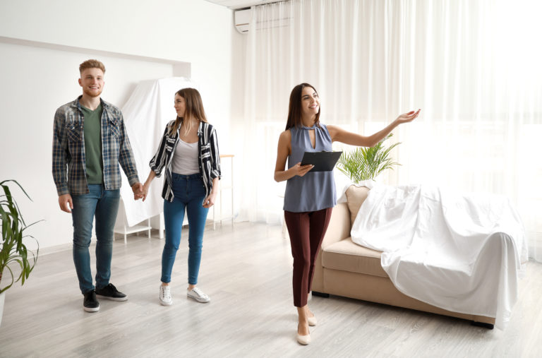 Real estate agent showing young couple a new house