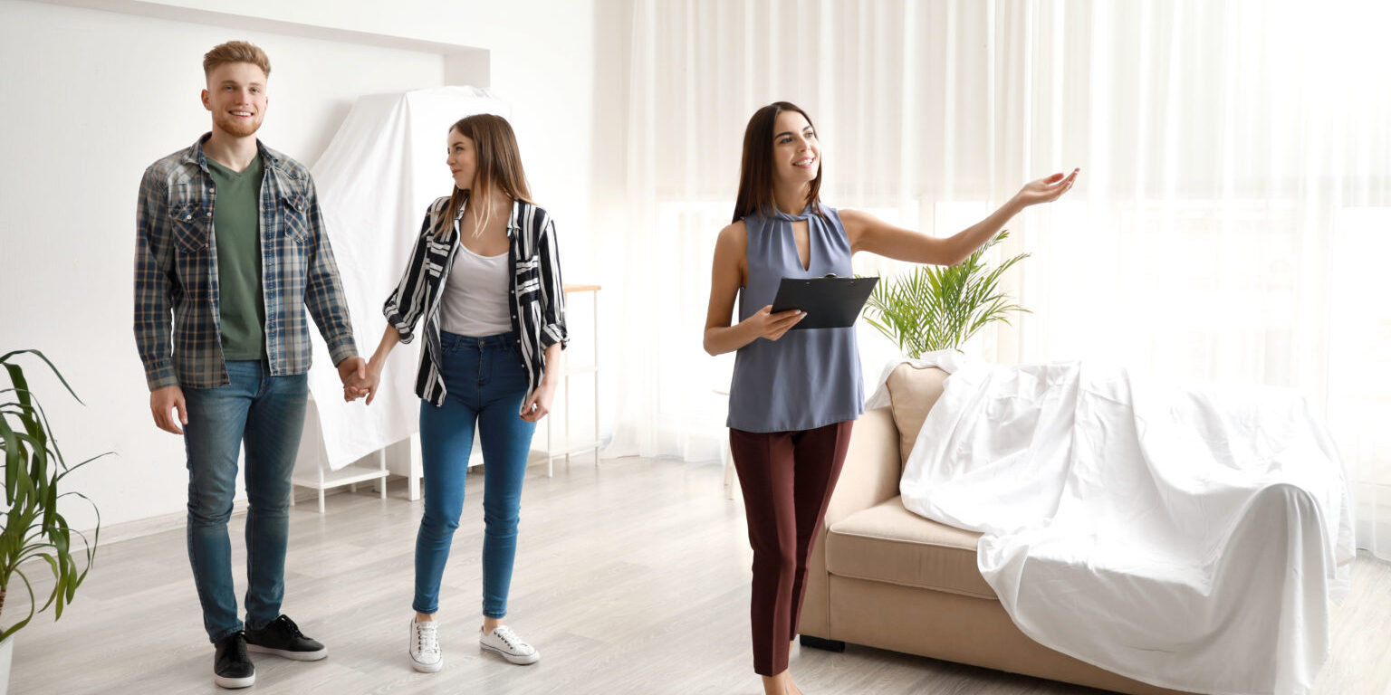 Real estate agent showing young couple a new house