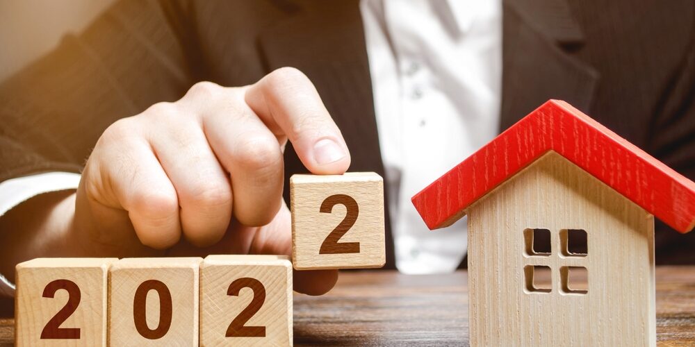 A,Businessman,Making,2022,Out,Of,Blocks,Near,House.,Concept