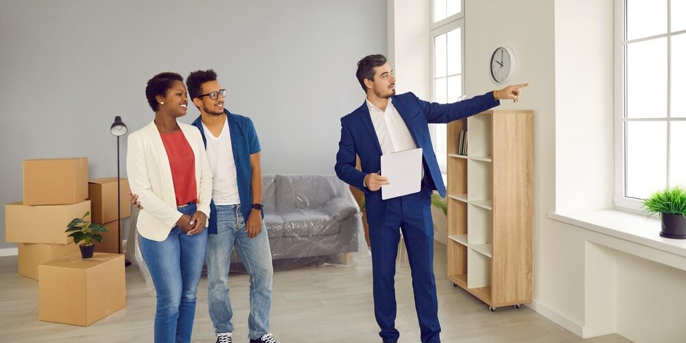 Real estate agent showing two buyers a home